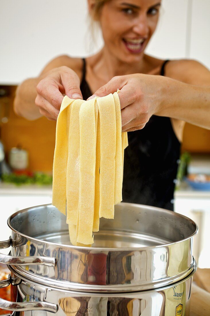 Putting home-made pappardelle into boiling water