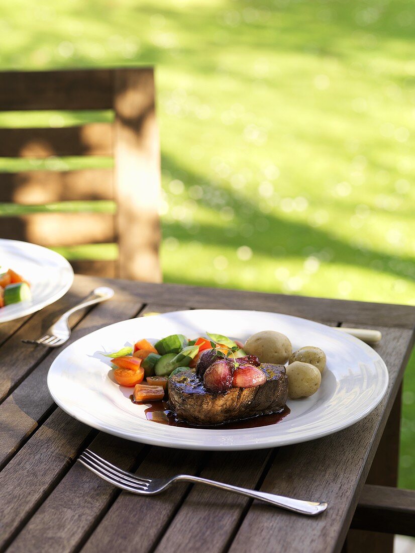 Beefsteak with shallot sauce, vegetables, potatoes out of doors