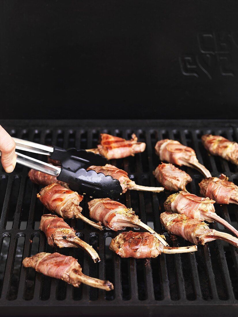 Bacon-wrapped lamb chops on a barbecue