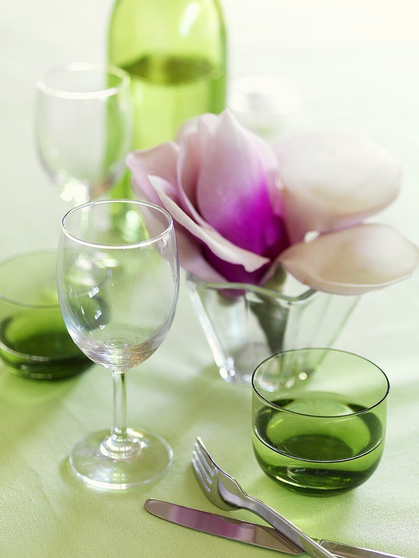 Gläser und Blumen für frühlingshaft gedeckten Tisch