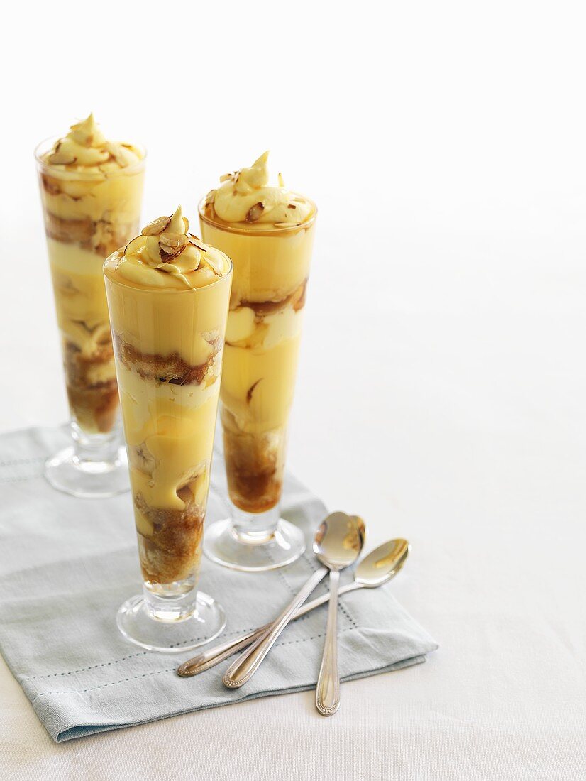 Banana trifle with almond custard in three glasses