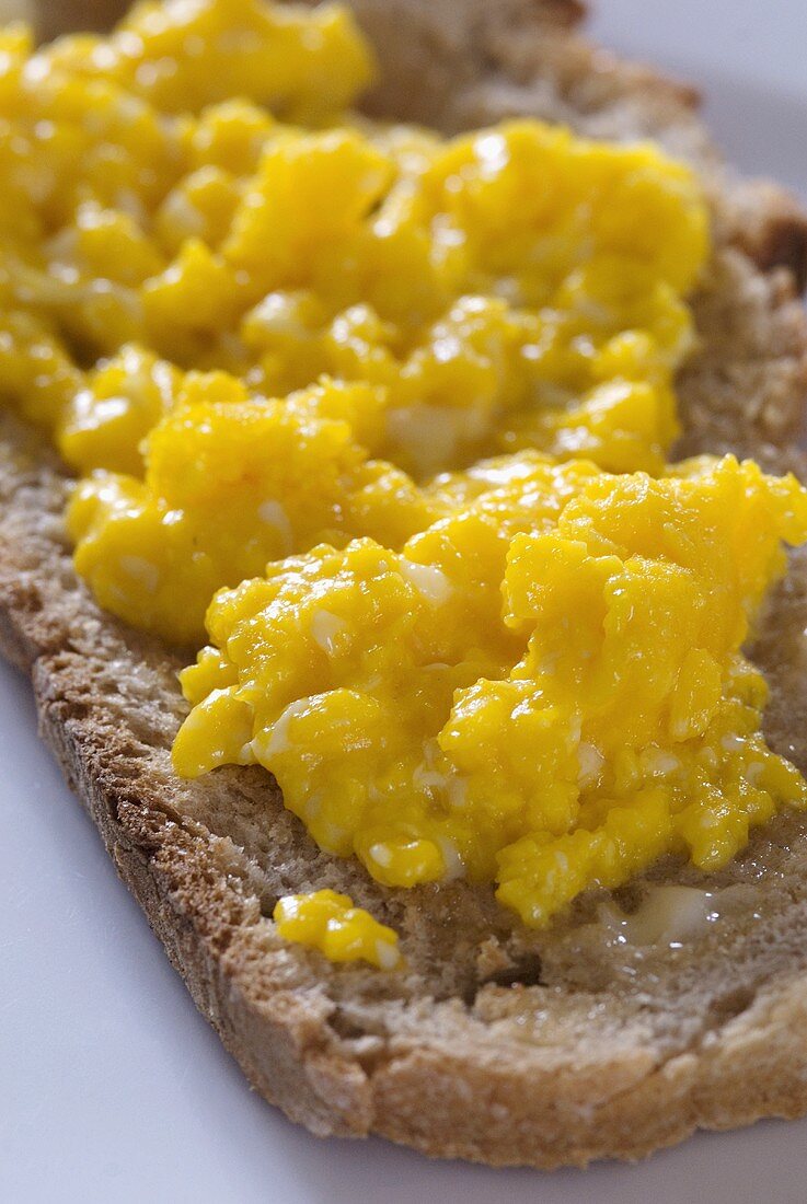 Rührei auf getoastetem Brot mit Butter (Close up)