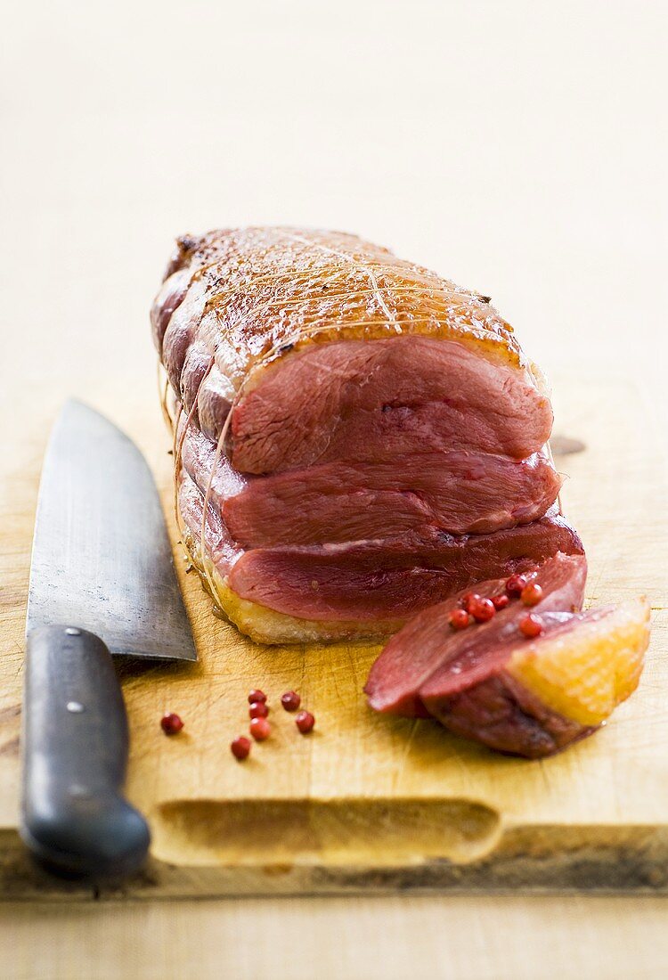 Roast duck breasts (tied together) with red peppercorns