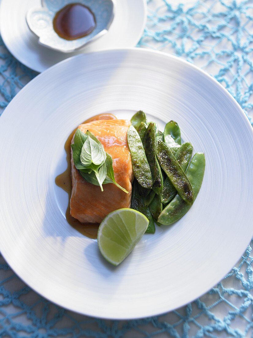 Salmon with soy sauce and maple syrup served with mangetout
