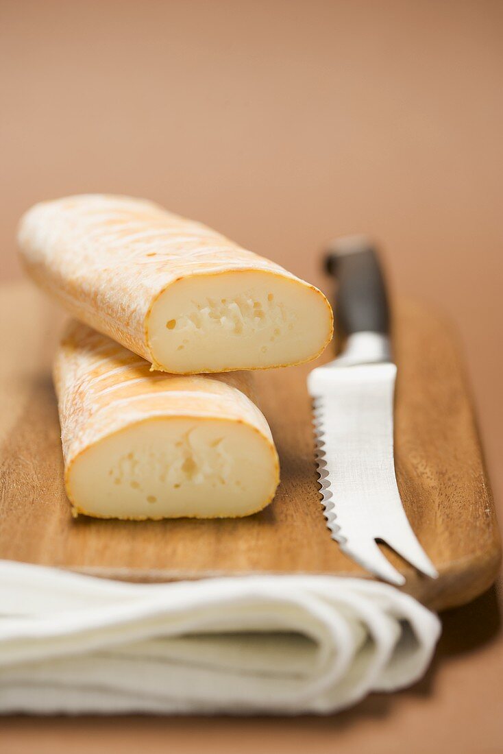 Cow's milk cheese and cheese knife on chopping board