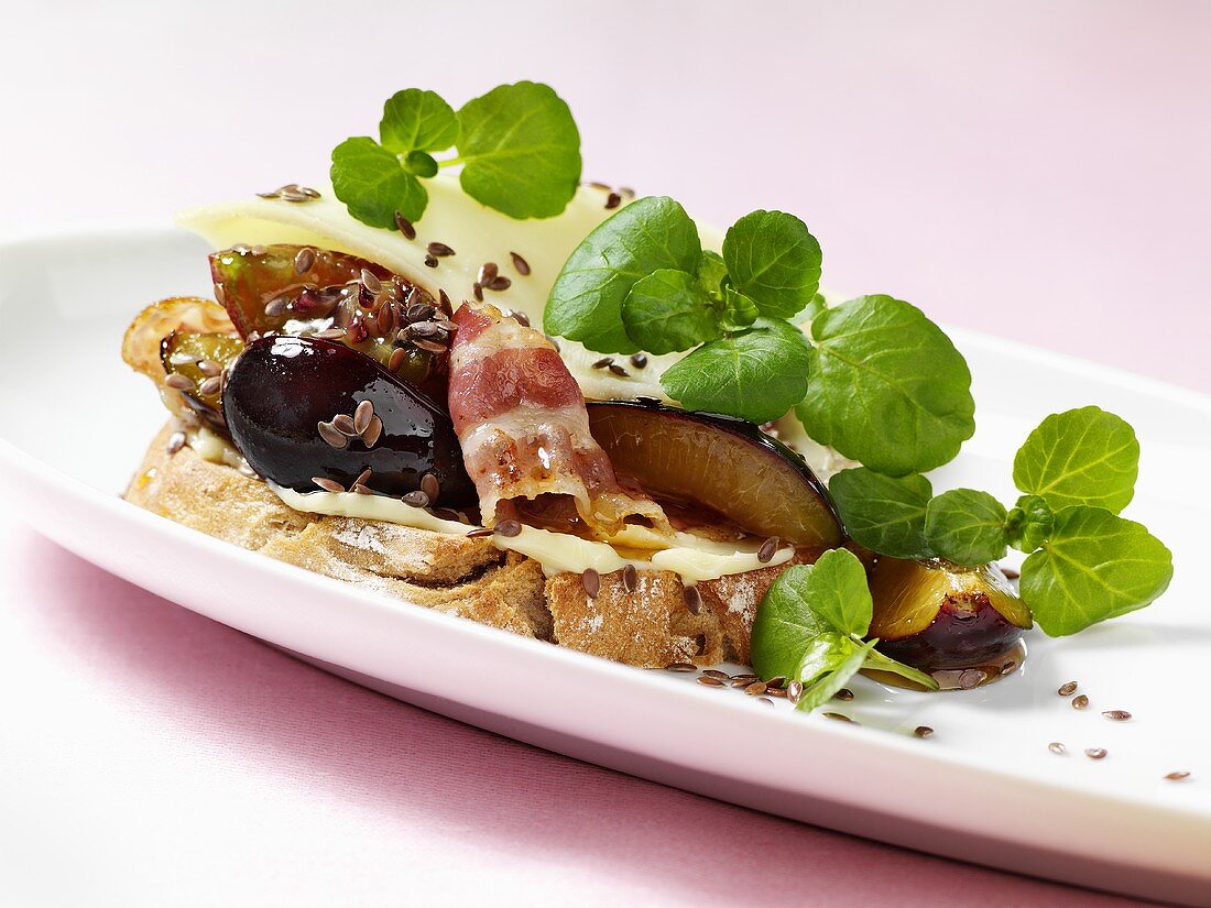 Fried bacon, plums and linseed on bread