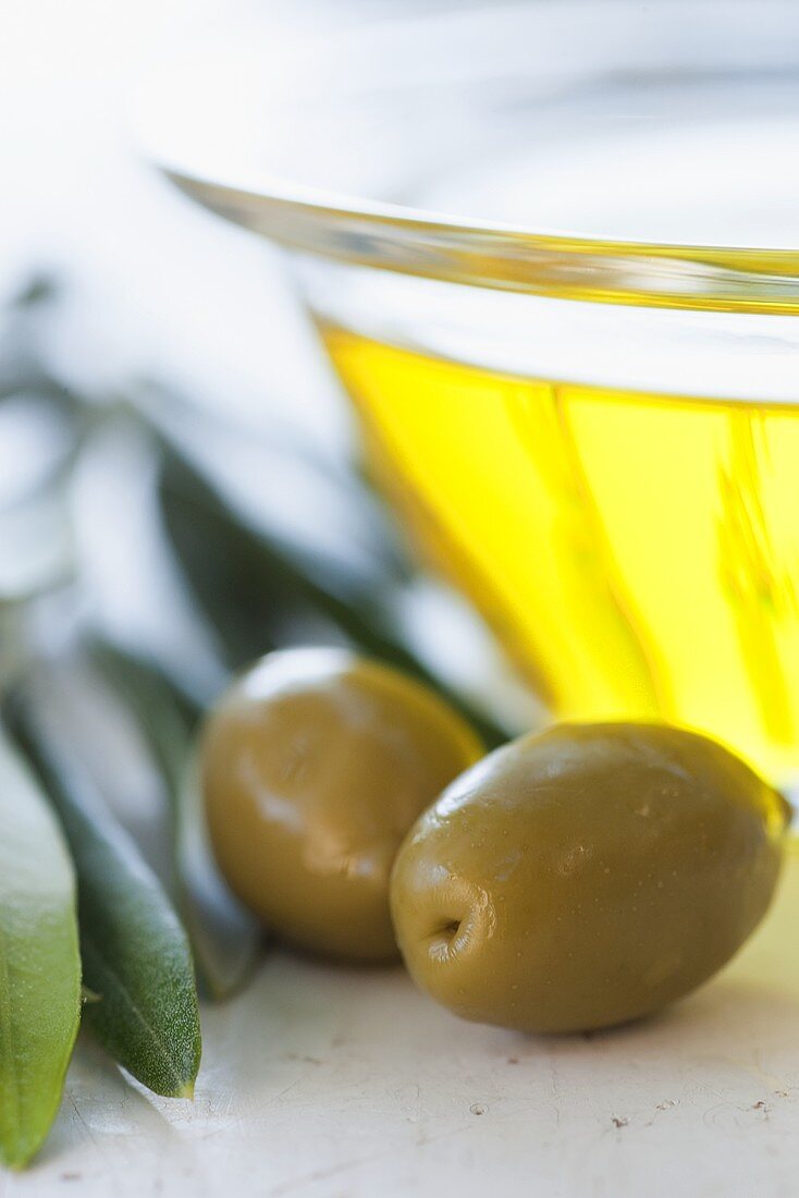 Ein Glasschälchen Olivenöl und Oliven