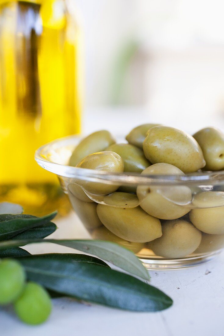 A bowl of pickled olives, olive oil, fresh olives