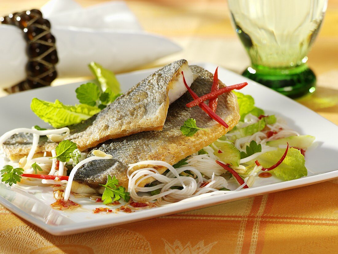 Sea bass fillets with rice noodles and salad leaves