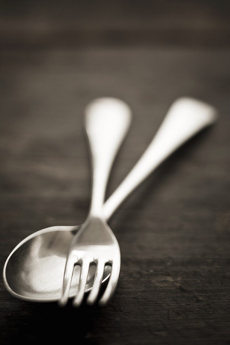 Silver spoon and fork on wooden background