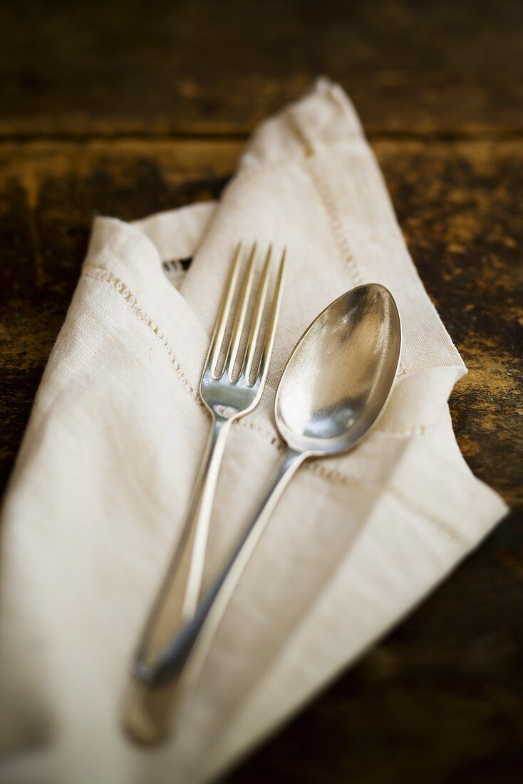 Antique silver spoon and fork on fabric napkin