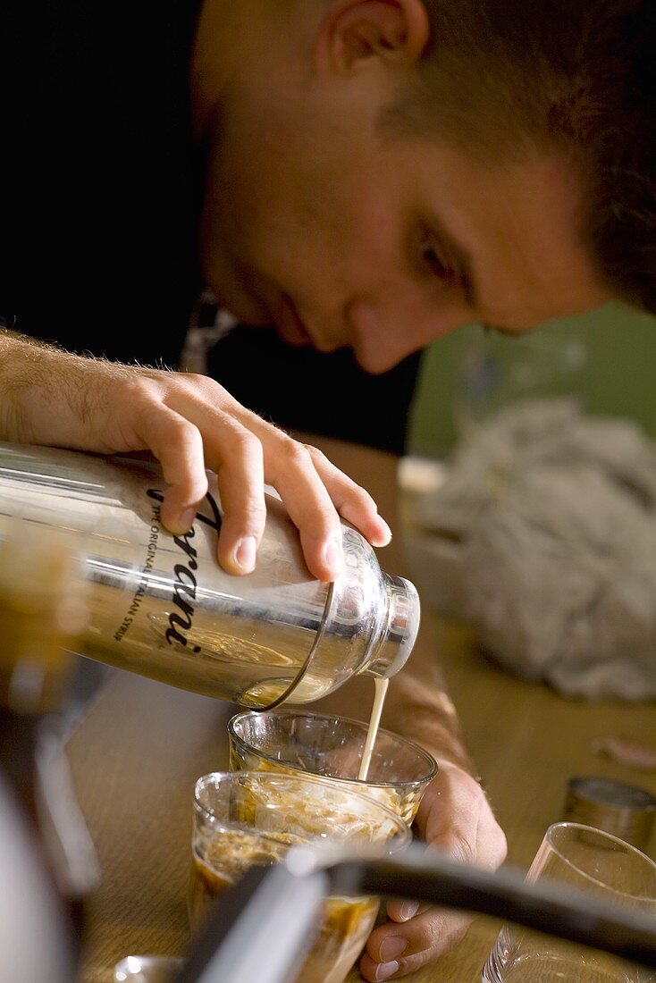 Junger Mann mixt einen Kaffee-Drink