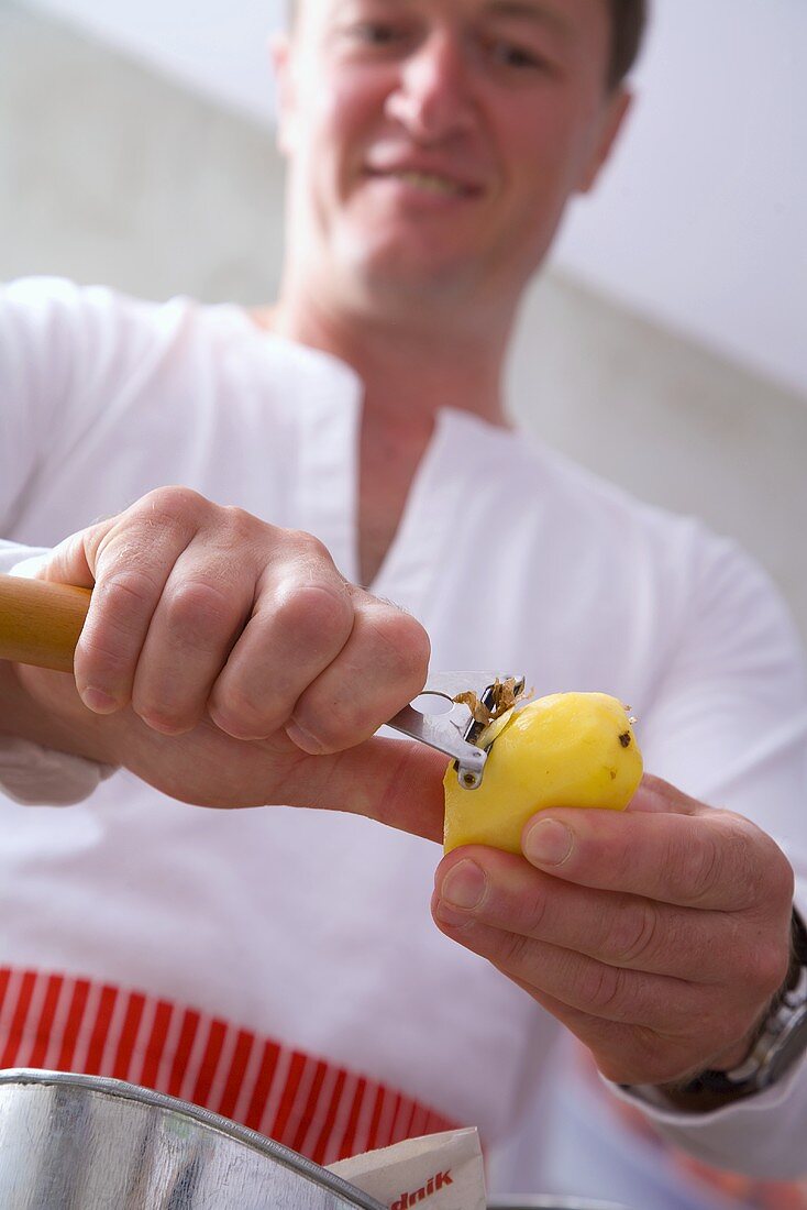 Man peeling a potato