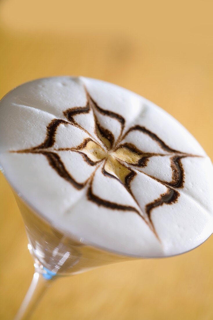 Tiramisu-Kaffee in einem Glas mit Muster auf Milchschaum