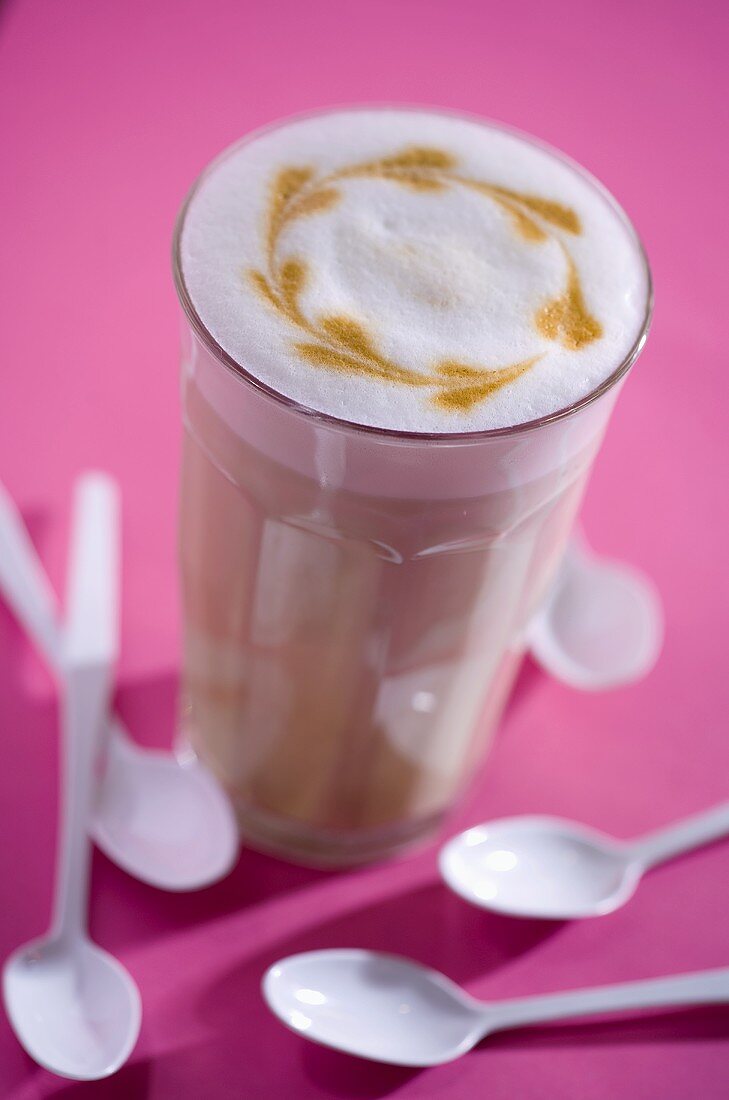 Ein Glas Café Latte mit Muster im Milchschaum