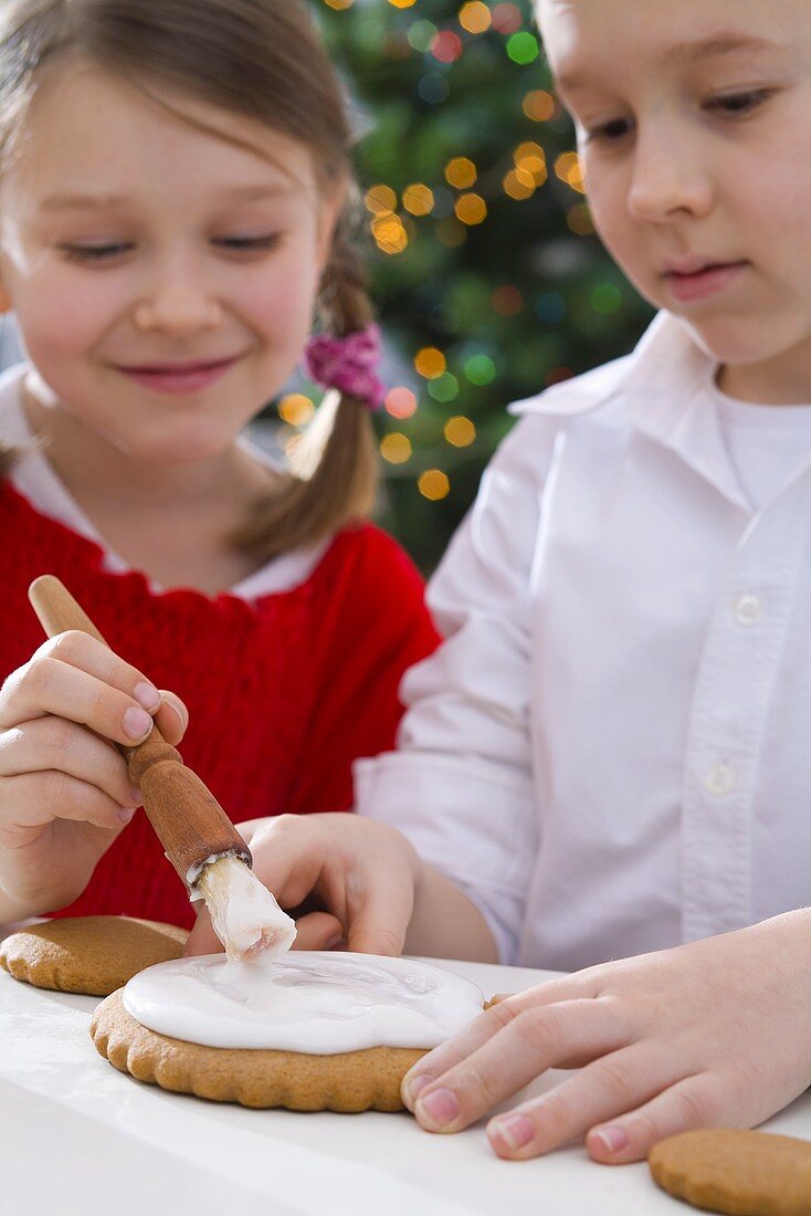 Kinder machen Ingwerkeks-Weihnachtsbäumchen