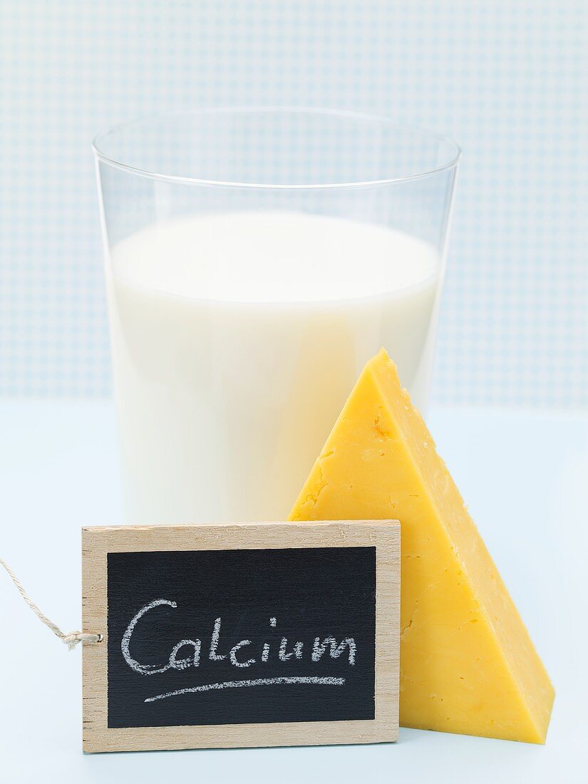 Cheddar cheese, milk and slate board with the word Calcium