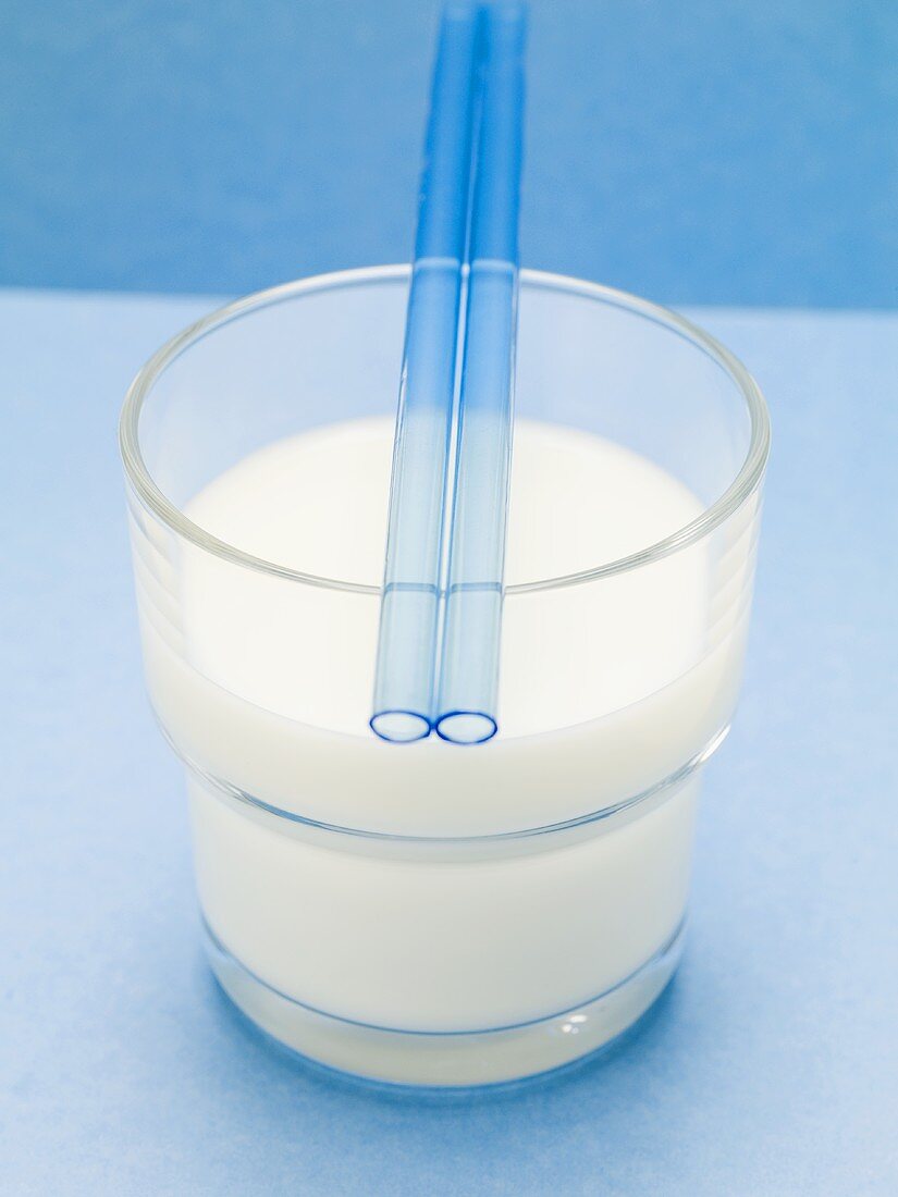 Blue straws on glass of milk