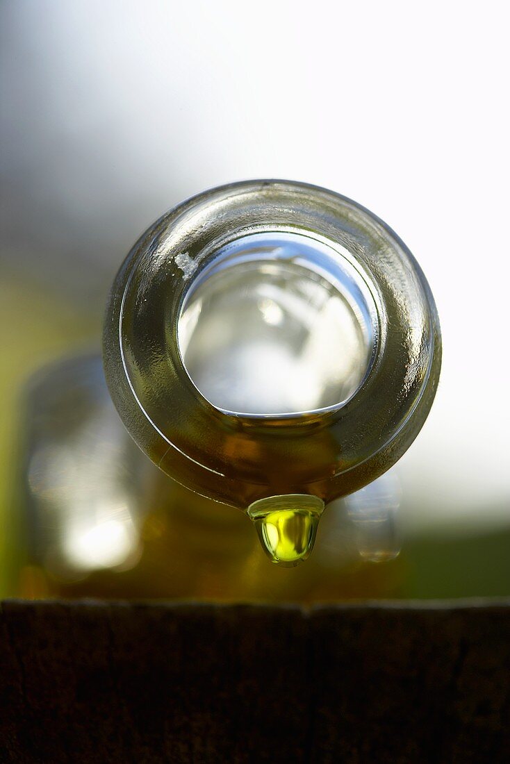 Olive oil dripping out of bottle