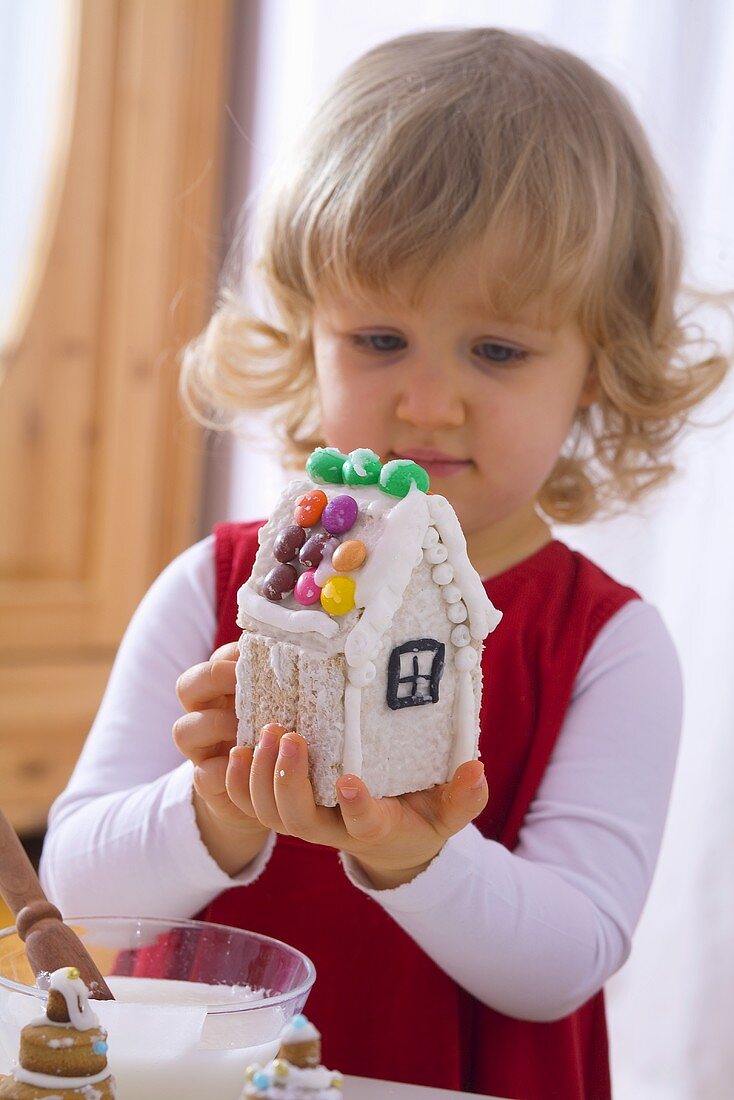 Kleines Mädchen mit verziert ein Lebkuchenhaus