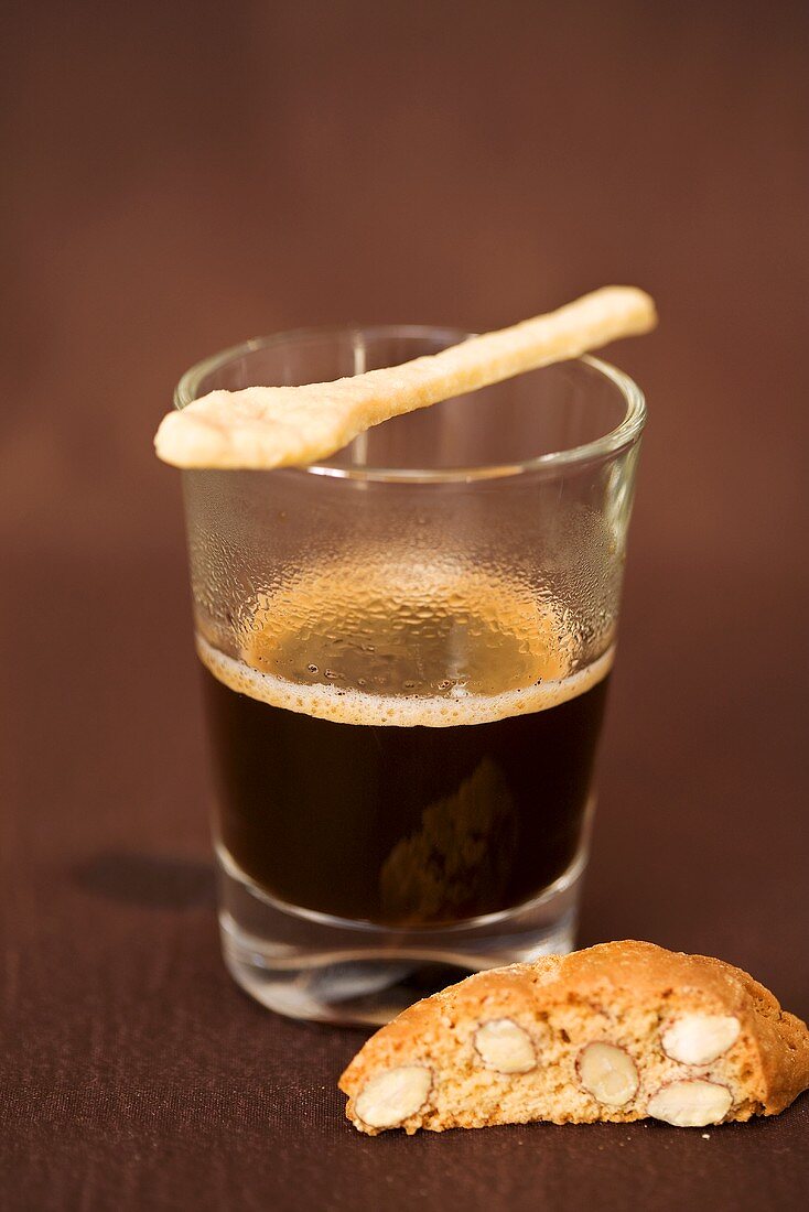 Espresso with spoon-shaped biscuit and biscotti