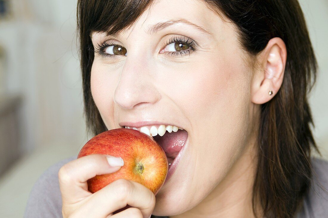 Junge Frau beißt in einen Apfel