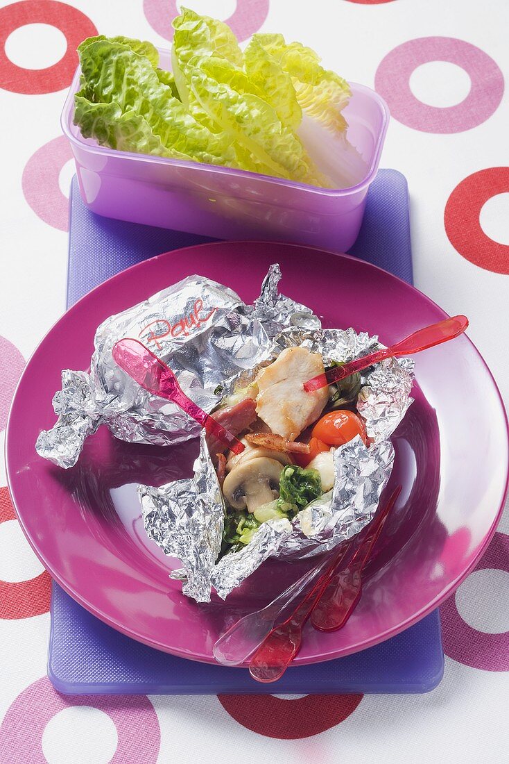 Pieces of chicken and vegetables cooked in foil