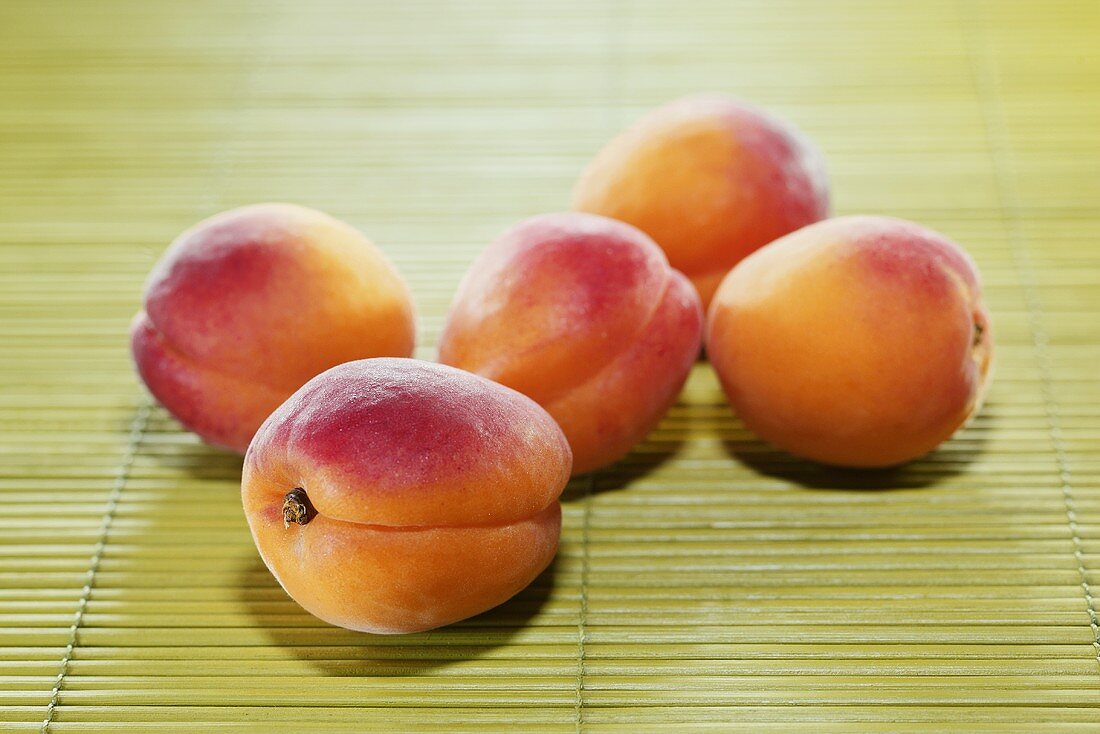 Five apricots on bamboo mat