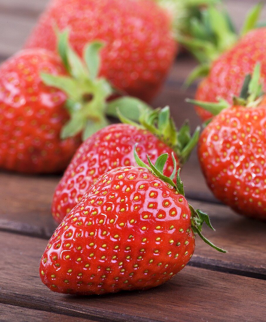 Fresh strawberries on wooden table (close-up)