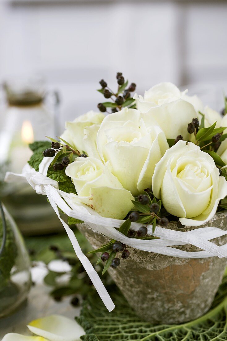 Arrangement of white roses and myrtle in resin pot