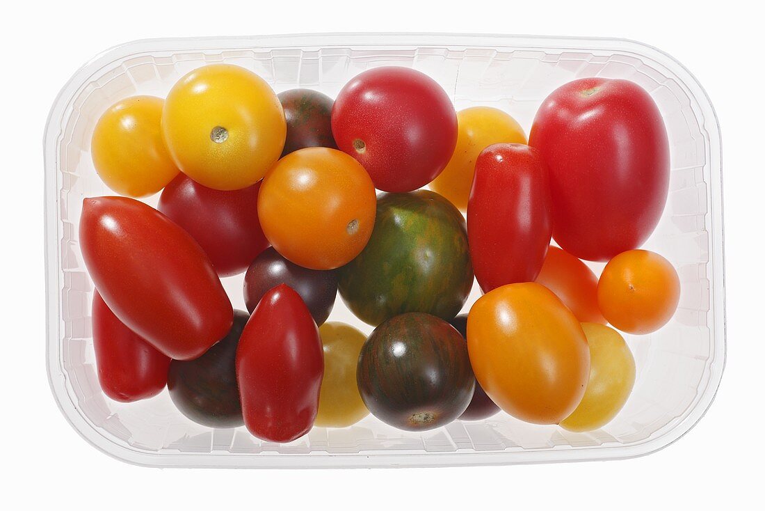 Assorted tomatoes in plastic container from above