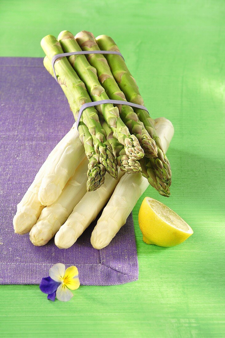 A bundle of green asparagus, white asparagus and lemon