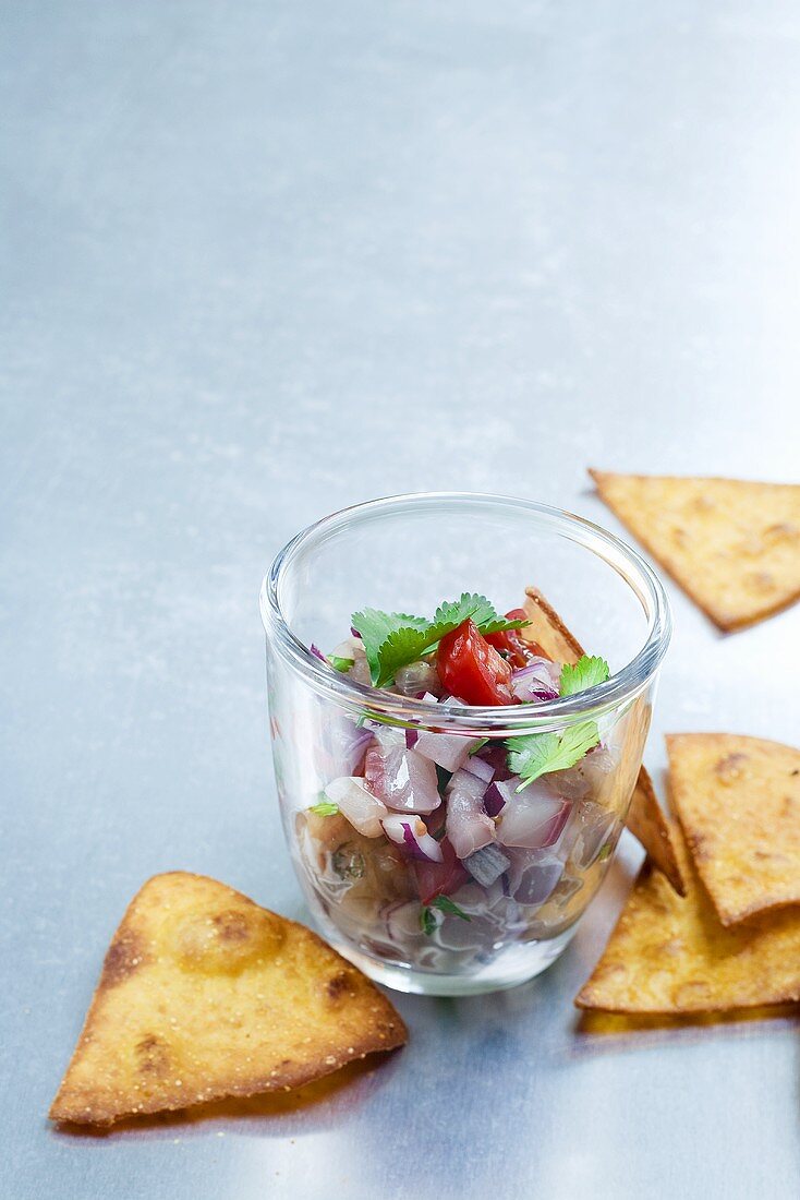 Ceviche with coriander in a glass, with bread chips