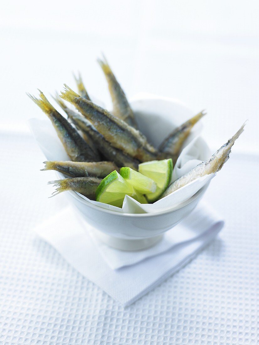 Deep-fried anchovies with lime wedges