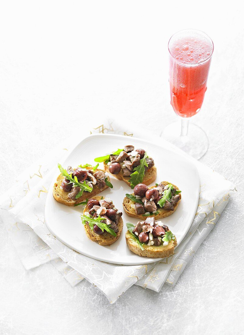 Crostini mit gebratener Ente, Kirschen, Rucola und Negroni