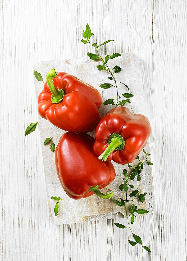 Red peppers with herbs on a chopping board