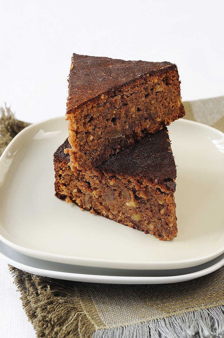 Two pieces of chocolate cake with almonds and dates