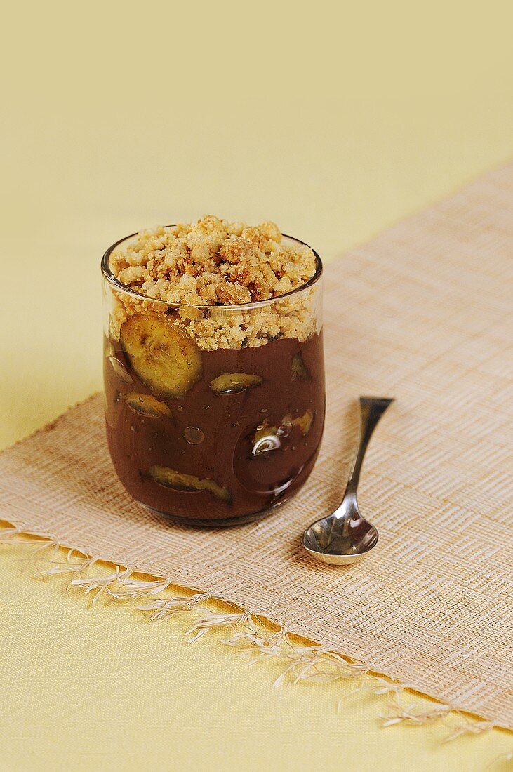 Chocolate cream with bananas and crumble in glass