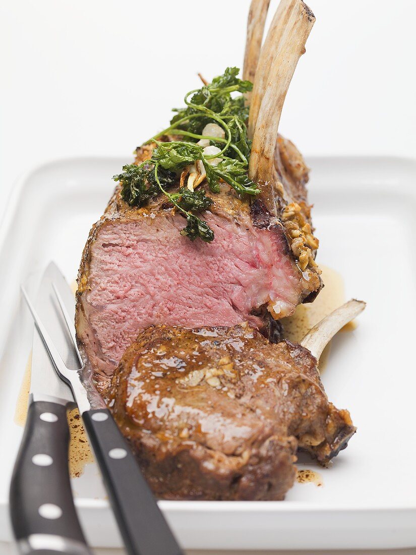 Roast rack of lamb with parsley and garlic on platter
