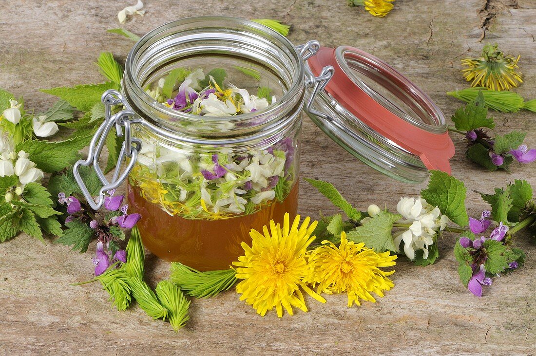 Fichtenspitzen, Blütenblätter und ein Honigglas