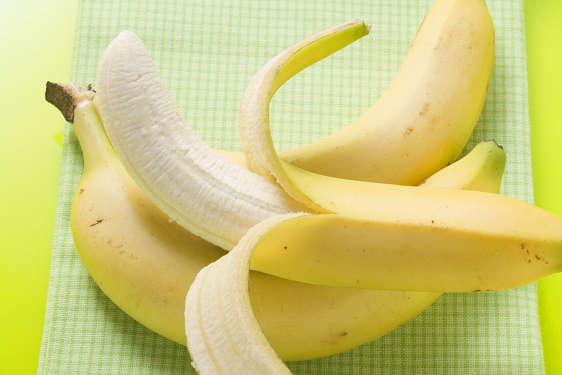 Three bananas on green background