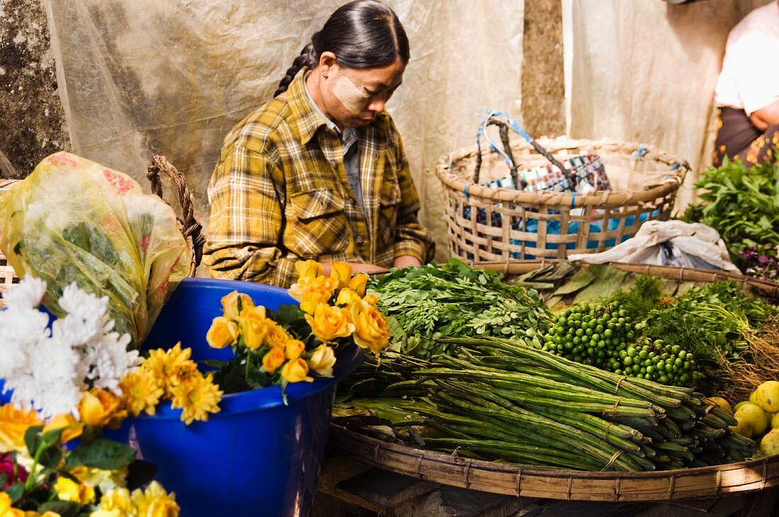 Frau an einem Blumen- und Gemüsemarkt in Burma