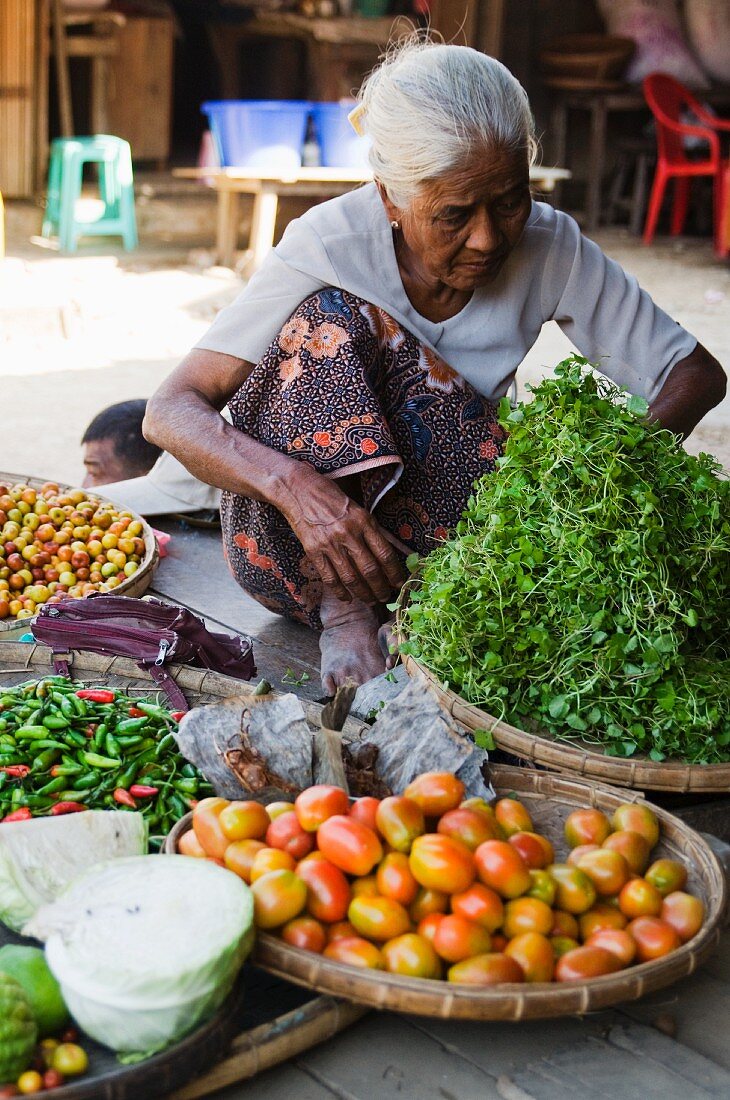 Ältere Frau verkauft Gemüse auf einem Markt in Burma