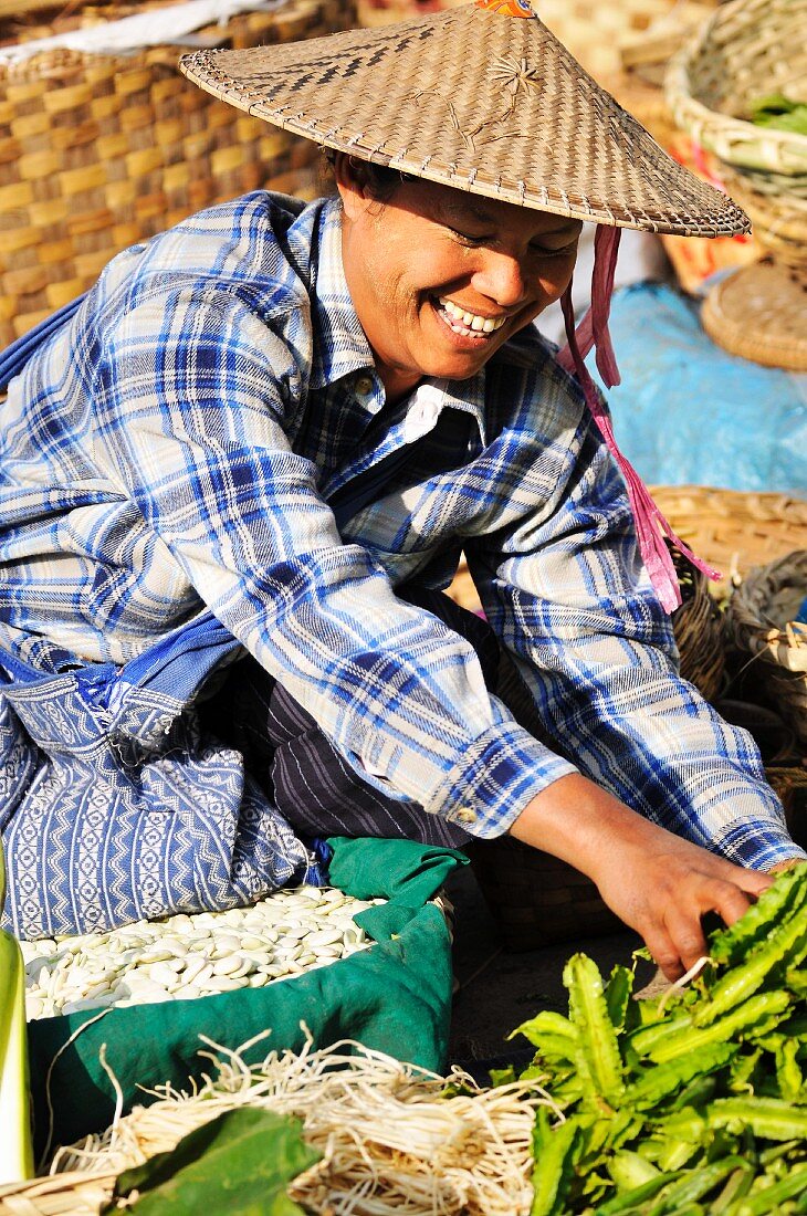 Lachender Verkäufer auf einem Markt in Burma