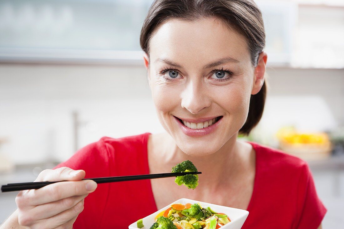 Woman eating Asian vegetables