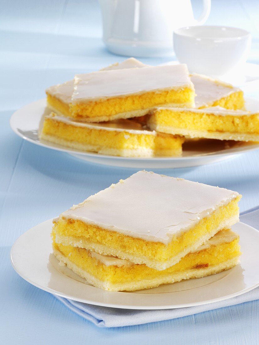 Several pieces of iced orange cake