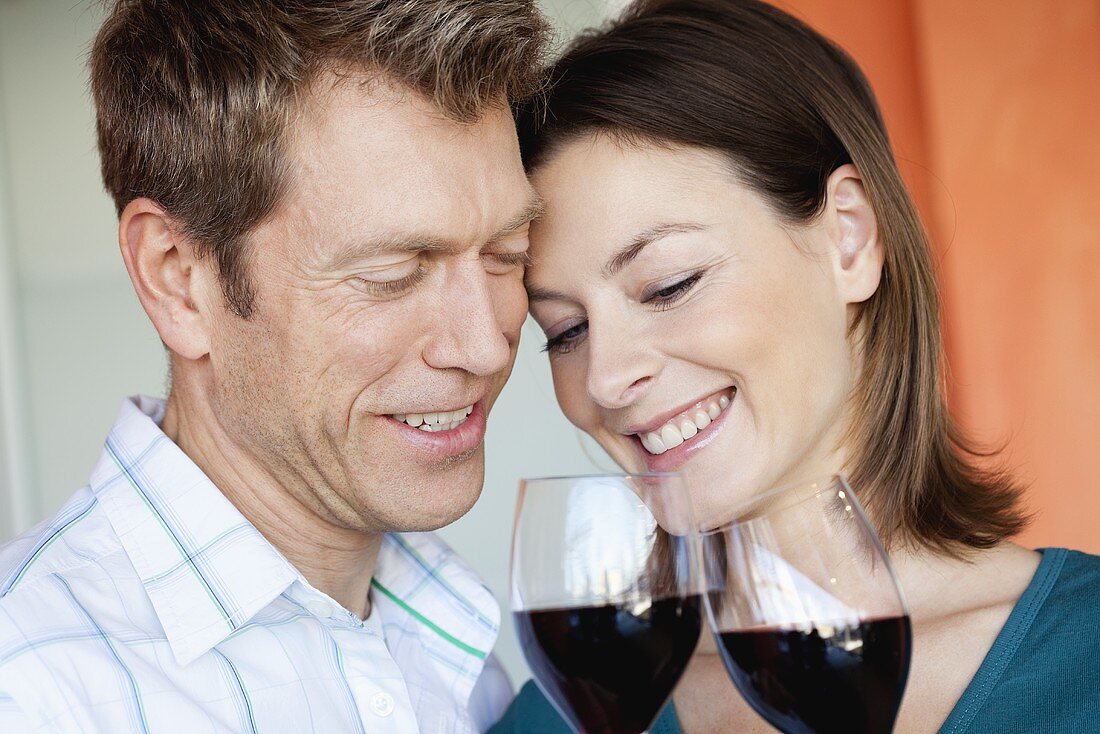 Courting couple clinking glasses of red wine