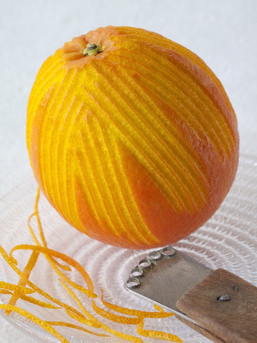 Orange mit Orangenzesten und Zestenreisser