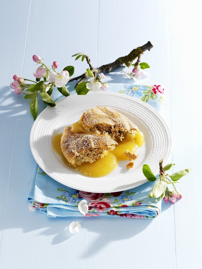 Apple pudding on plate surrounded by apple blossom