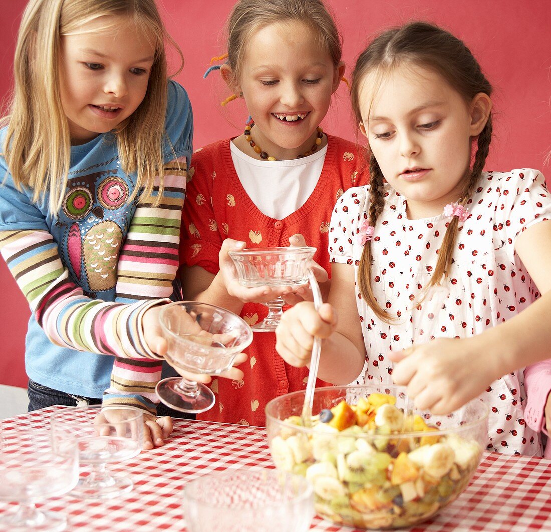 Drei Mädchen essen Obstsalat